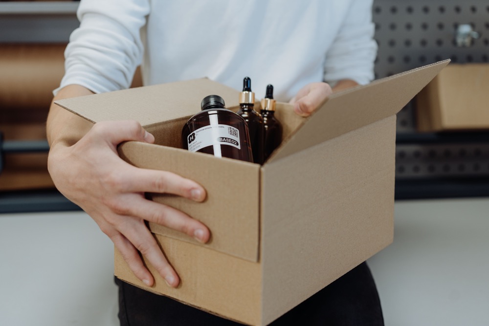 Verpacken der Bestellung — Fläschchen mit Rohstoffen im Karton