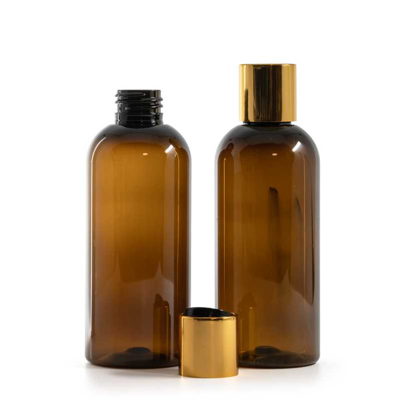 Bernsteinfarbene Kunststoffflasche, schwarzer Kunststoff-Kippverschluss mit goldenem Aluminiumkragen
