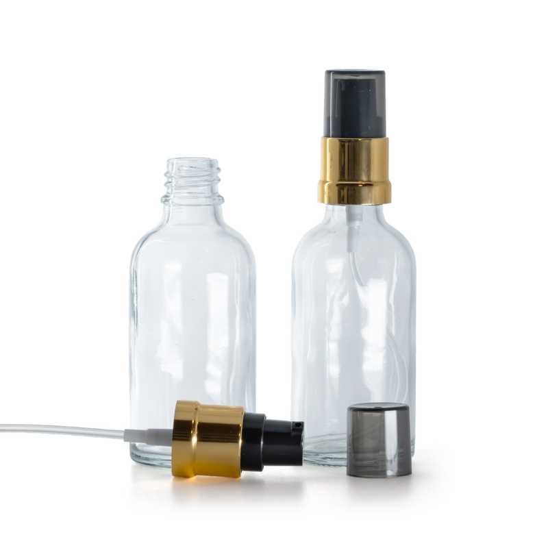 Transparentes Glasfläschchen, glänzende schwarz-goldene Pumpe mit rauchfarbener Überkappe, 50 ml